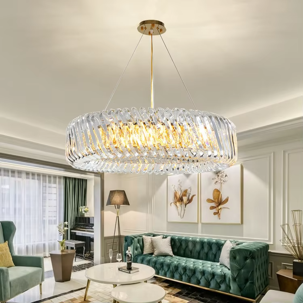 This modern light luxury linear crystal chandelier features a gold metal ceiling base, enclosed by wavy transparent crystal strips to form a full linear shape. When lit, light refracts through the crystal to emit a brilliant and soft glow, combining a transparent texture with an ambient atmosphere. Ideal for dining rooms, bars, light luxury apartments, and other spaces, it adds an exquisite and sophisticated touch to modern minimalist or light luxury home environments.