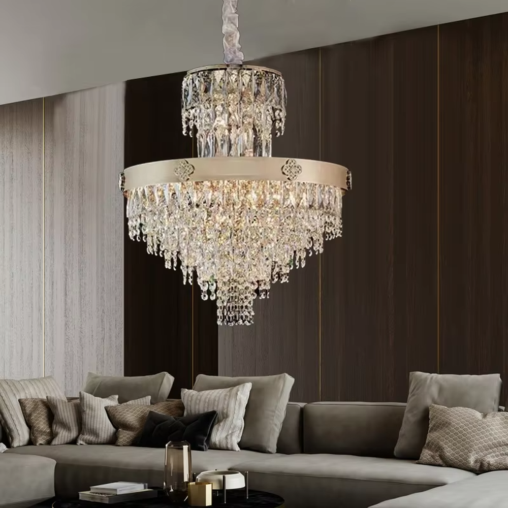 This European luxury two-layer conical crystal chandelier features a champagne gold metal frame, with dense long crystals hanging down to form a two-layer conical layered shape, suspended by a braided cord. When lit, light refracts through the crystals to emit a brilliant and luxurious glow, combining a luxurious texture with an ambient atmosphere. Ideal for villa living rooms, luxury dining rooms, high-end clubs, and other spaces, it adds an elegant and exquisite touch to European luxury or modern light luxury environments.