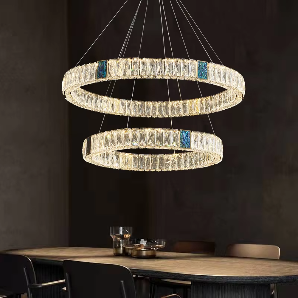 This light luxury and grand multi-layer conical crystal chandelier features a gold metal frame, with vertical-textured glass lampshades on the upper layer and multiple layers of transparent crystal tassels hanging below, creating a full conical shape. When lit, light refracts through the crystal to emit a brilliant and luxurious glow, combining elegant texture with an ambient atmosphere. Ideal for living rooms, dining rooms, villa high-ceiling spaces, and other areas, it adds an elegant and exquisite touch to European light luxury or modern luxury home environments.