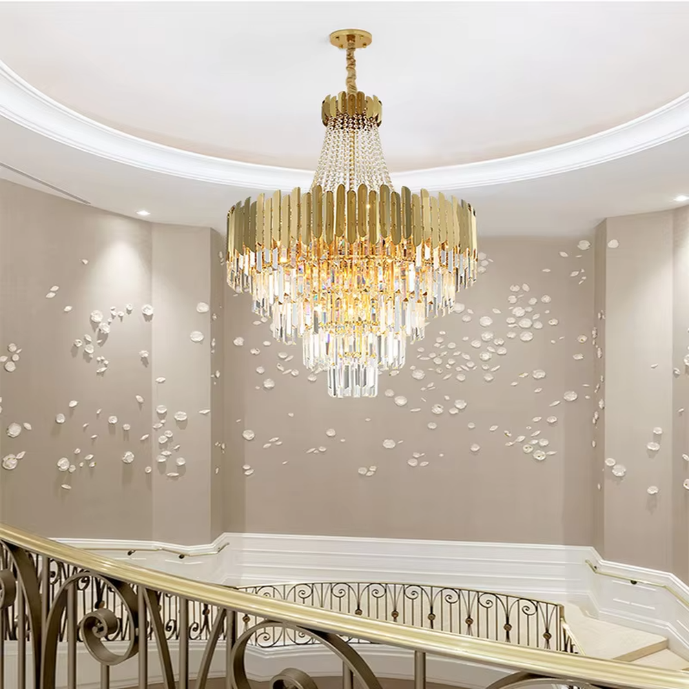This light luxury and grand multi-layer crystal chandelier features a gold metal frame, paired with transparent crystal pendants and metal decorative pieces, creating a layered conical shape. When lit, light refracts through the crystal to emit a brilliant and luxurious glow, combining decorative appeal with an ambient atmosphere. Ideal for villa living rooms, high-ceiling spaces, hotel lobbies, or duplex foyers, it adds an elegant and exquisite touch to modern light luxury or European-style luxury spaces.