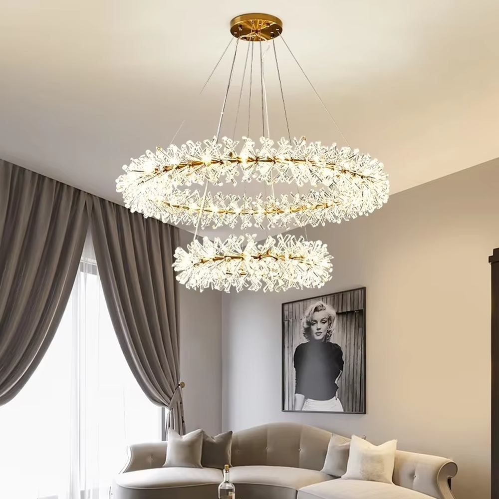 This modern light luxury multi-layer circular chandelier features a gold metal frame, inlaid with transparent snowflake-shaped crystal modules, combined into a three-layer staggered circular shape. When lit, light refracts through the crystal to emit a brilliant and soft glow, combining an ethereal feel with an ambient atmosphere. Ideal for living rooms, dining rooms, light luxury apartments, and other spaces, it adds a dreamy and exquisite touch to modern minimalist or French light luxury home environments.