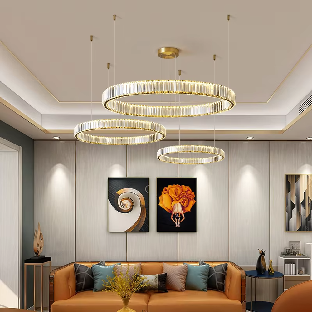 This modern light luxury multi-layer circular crystal chandelier features gold metal frames, inlaid with transparent long crystals to create three groups of staggered circular shapes. When lit, light refracts through the crystals to emit a brilliant and soft glow, combining a layered texture with an ambient atmosphere. Ideal for high-ceiling living rooms, duplex apartments, light luxury apartments, and other spaces, it adds an exquisite and sophisticated touch to modern minimalist or light luxury home environments.