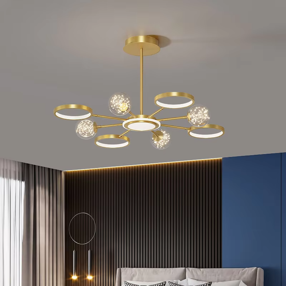 This modern light luxury radial chandelier features a gold metal frame with multiple radially extending arms, paired with glowing rings and glass ball lampshades with a starry sky effect. When lit, it emits a bright and soft glow, combining a futuristic feel with an ambient atmosphere. Ideal for living rooms, large apartments, and light luxury residences, it adds an exquisite and sophisticated touch to modern minimalist or light luxury home environments.
