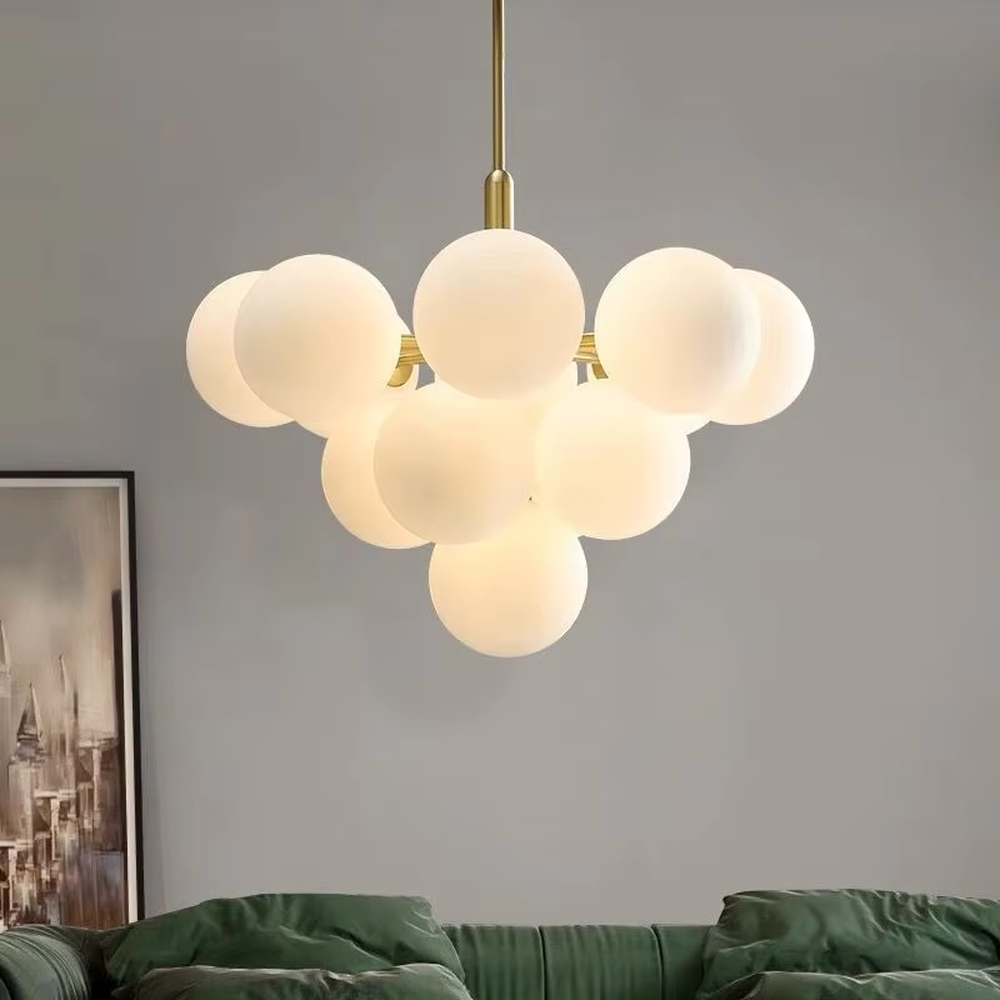 Modern healing cloud magic bean chandelier, featuring a brass metal frame paired with fluffy milk-white frosted glass balls to form a cloud shape. It emits soft and gentle light, combining a dreamy feel and cozy ambiance, making it a decorative lighting fixture that enhances the warmth of the space.