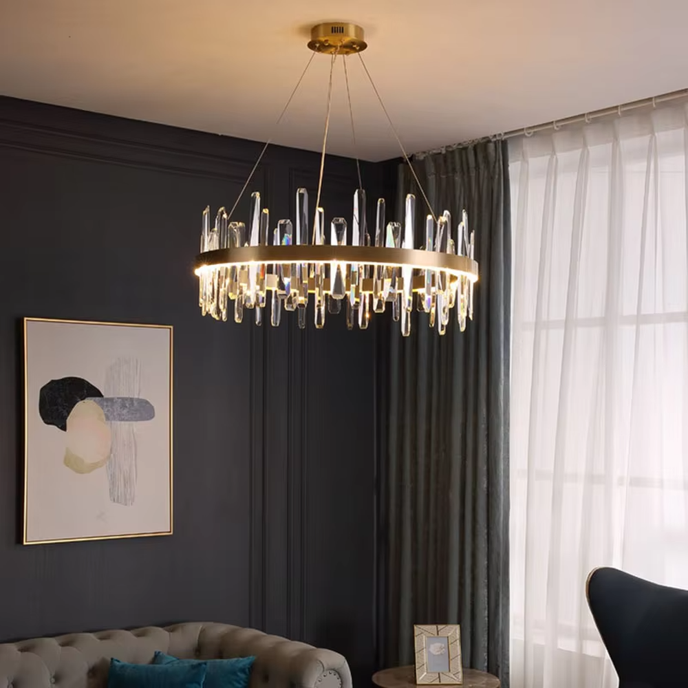 This modern light luxury circular crystal chandelier features a gold metal frame, with transparent crystal strips of varying lengths hanging down to form a staggered circular shape. When lit, light refracts through the crystal to emit a brilliant and dynamic glow, combining an exquisite texture with an ambient atmosphere. Ideal for dining rooms, living rooms, light luxury apartments, and other spaces, it adds an exquisite and sophisticated touch to modern minimalist or light luxury home environments.