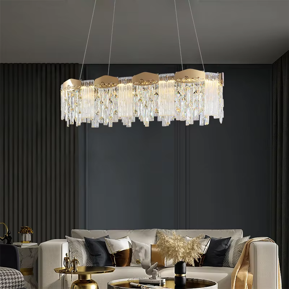 This modern light luxury linear crystal chandelier features a gold metal frame, with dense transparent long crystals hanging down and hollow-textured metal decorative blocks on top. When lit, light refracts through the crystal to emit a brilliant and soft glow, combining an exquisite texture with an ambient atmosphere. Ideal for dining rooms, bars, light luxury apartments, and other spaces, it adds an exquisite and sophisticated touch to modern minimalist or light luxury home environments.