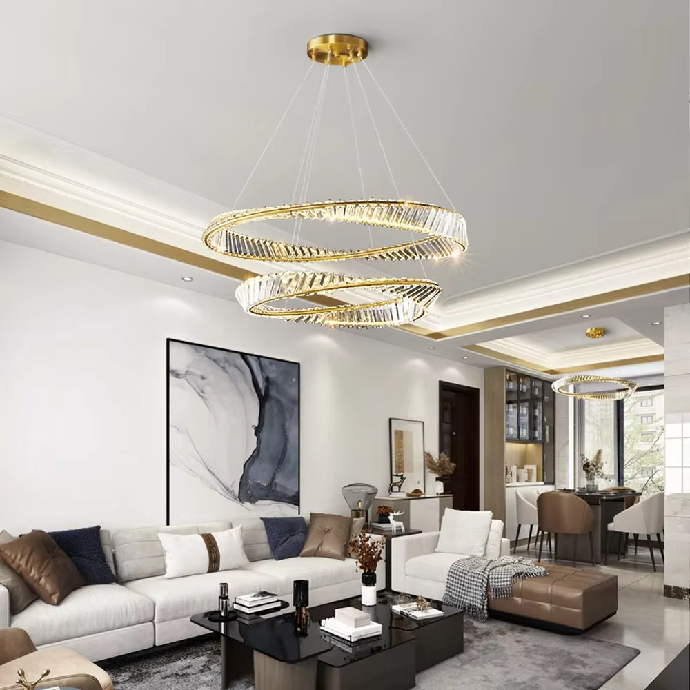 This modern light luxury interwoven ring crystal chandelier features a gold metal frame, inlaid with transparent long crystals to create a dynamic interwoven double-ring shape. When lit, light refracts through the crystal to emit a brilliant and soft glow, combining a futuristic feel with an ambient atmosphere. Ideal for dining rooms, living rooms, light luxury apartments, and other spaces, it adds an exquisite and sophisticated touch to modern minimalist or light luxury home environments.