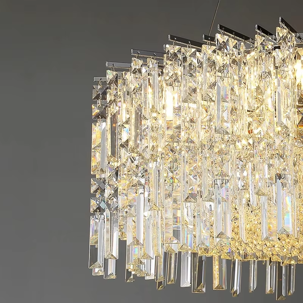 This modern light luxury square crystal chandelier features a silver metal frame, with dense transparent long crystals hanging down to form a square shape. When lit, light refracts through the crystal to emit a brilliant and soft glow, combining an exquisite texture with an ambient atmosphere. Ideal for bedrooms, dining rooms, light luxury apartments, and other spaces, it adds an exquisite and sophisticated touch to modern minimalist or light luxury home environments.