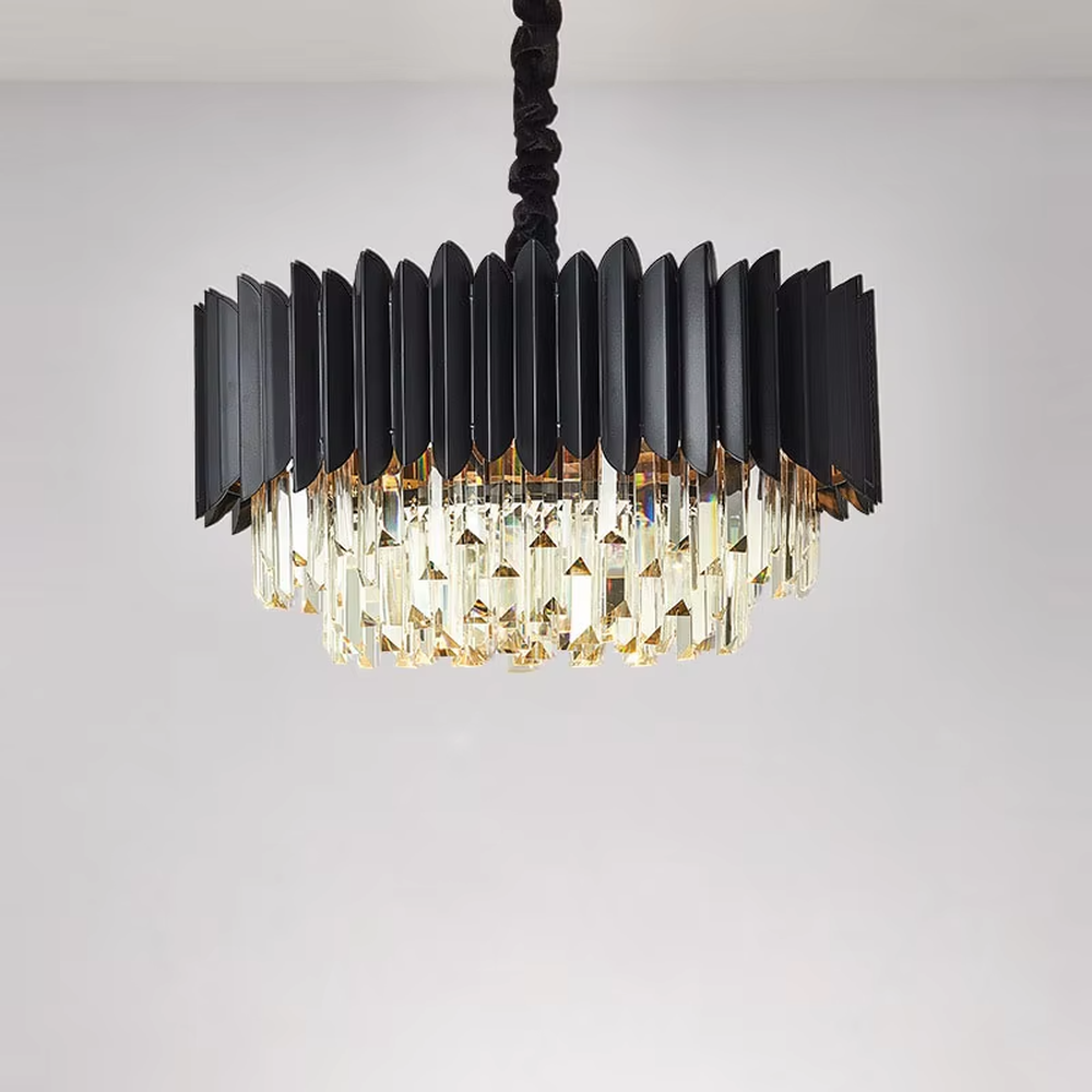 This modern light luxury two-layer chandelier features a dome shape enclosed by matte black vertical-textured metal on the upper layer, paired with transparent crystal tassel pendants on the lower layer, suspended by a black braided cord. When lit, light refracts through the crystal to emit a brilliant and soft glow, combining a sleek, bold texture with an elegant ambiance. Ideal for dining rooms, bedrooms, light luxury living rooms, and other spaces, it adds an exquisite and sophisticated touch to modern minimalist or industrial-style home environments.