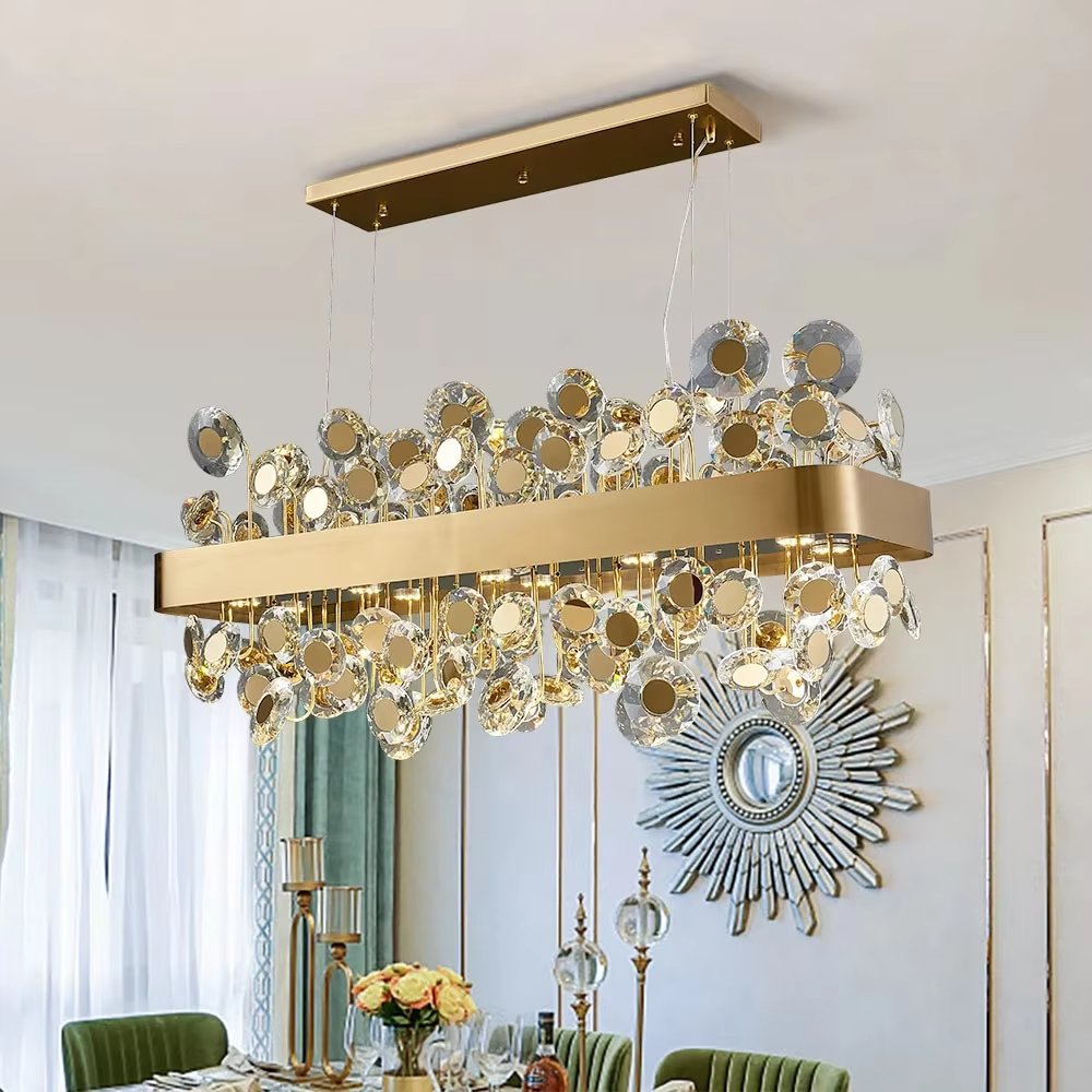 This modern light luxury rectangular crystal chandelier features a gold metal frame inlaid with multiple layers of circular-cut crystals and gold reflective discs. The staggered crystals create a brilliant and luxurious light effect when illuminated, combining decorative appeal with an ambient atmosphere. Ideal for dining rooms, bars, and above dining tables in light luxury apartments, it adds an elegant and exquisite touch to modern light luxury or European-style luxury spaces.
