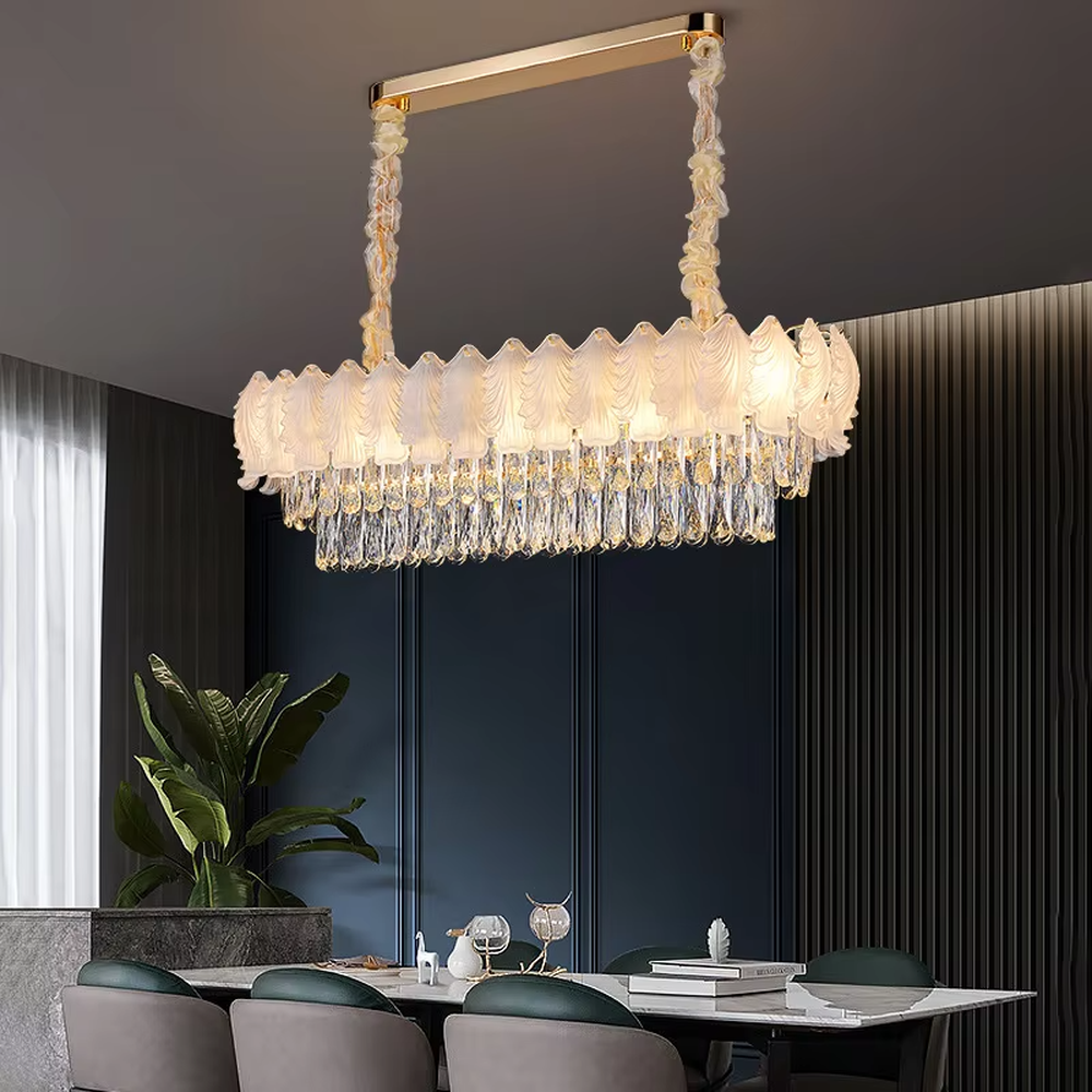 This modern light luxury linear crystal chandelier features a wavy upper lampshade made of transparent textured crystal slices, with dense crystal tassels hanging below, suspended by braided cords. When lit, light refracts through the crystal to emit a brilliant and soft glow, combining an ethereal texture with an ambient atmosphere. Ideal for dining rooms, bars, light luxury apartments, and other spaces, it adds a dreamy and exquisite touch to modern minimalist or French light luxury home environments.