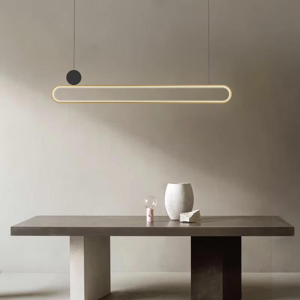 Modern light luxury black and gold linear chandelier, featuring a gold metal frame paired with a white luminous lamp body, accented with a black balancing ball on the side. Its clean and elegant lines combine style and ambiance, making it a modern home lighting fixture that enhances the space's texture.