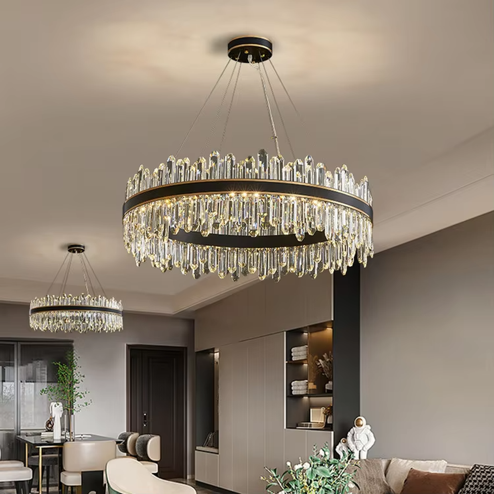 This modern light luxury two-layer circular crystal chandelier features a black-gold metal frame, with dense transparent long crystals hanging down to form a full circular shape. When lit, light refracts through the crystal to emit a brilliant and luxurious glow, combining a bold texture with an ambient atmosphere. Ideal for living rooms, dining rooms, light luxury apartments, and other spaces, it adds an exquisite and sophisticated touch to modern minimalist or light luxury home environments.