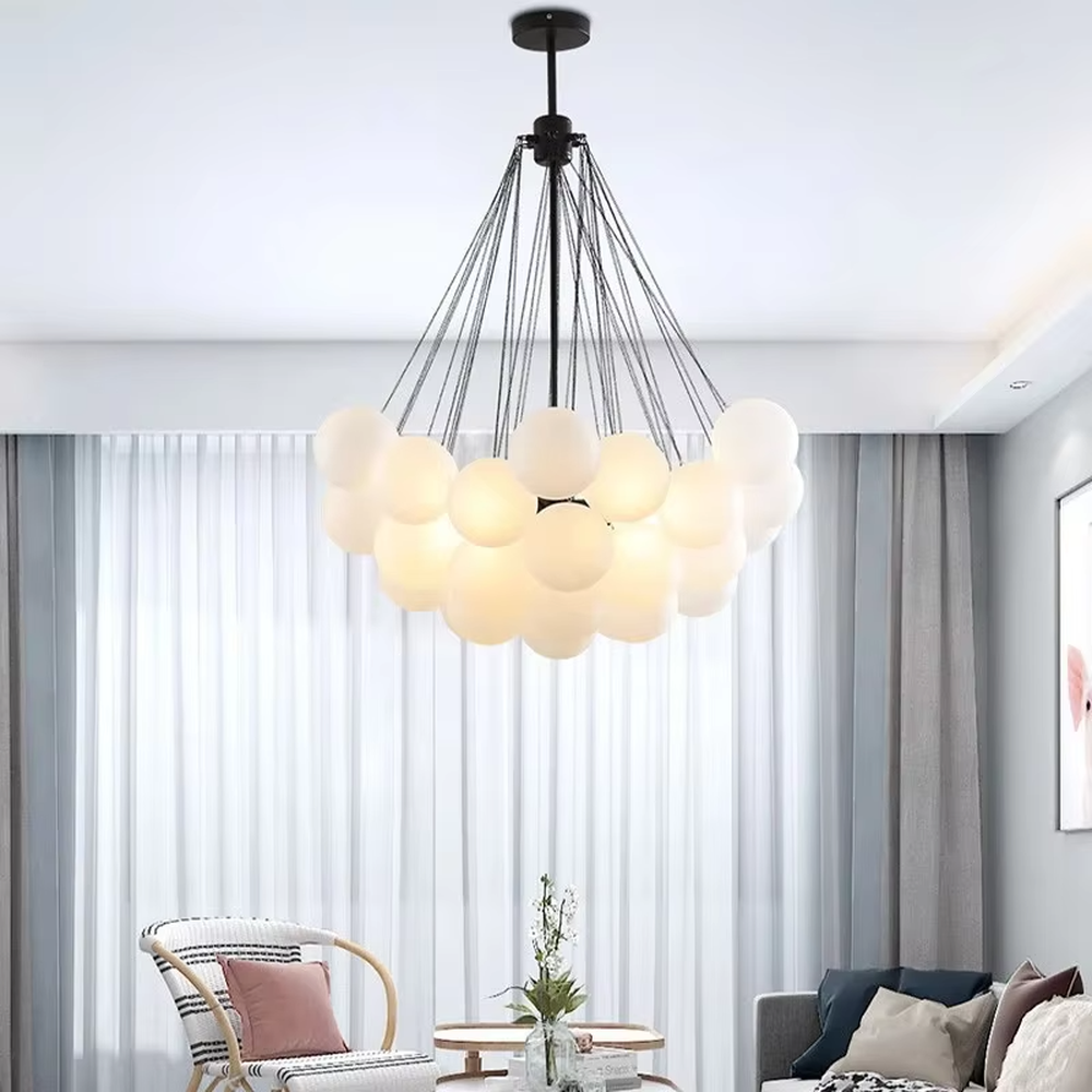 Modern healing cloud chandelier, featuring a radial suspension wire structure in black metal paired with fluffy milk-white frosted glass balls to form a cloud shape. It emits soft and gentle light, combining a dreamy feel and cozy ambiance, making it a decorative lighting fixture that enhances the warmth of the space.