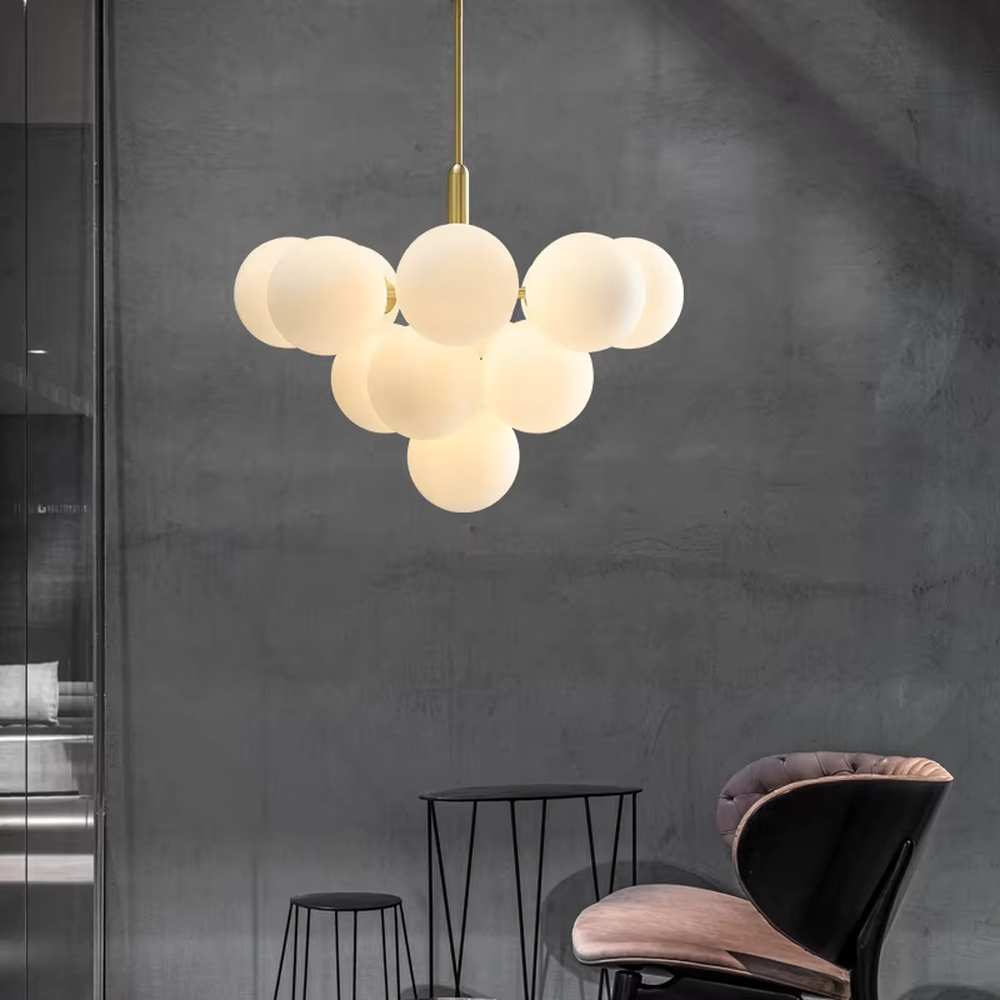 Modern healing cloud magic bean chandelier, featuring a brass metal frame paired with fluffy milk-white frosted glass balls to form a cloud shape. It emits soft and gentle light, combining a dreamy feel and cozy ambiance, making it a decorative lighting fixture that enhances the warmth of the space.