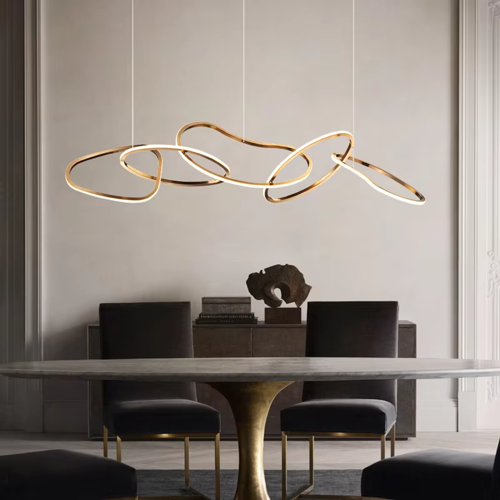 Modern light luxury flowing ring chandelier, featuring interwoven and irregular gold metal rings with built-in soft LED lighting. Its dynamic and elegant lines combine artistry and ambiance, making it a high-end decorative lighting fixture that elevates the space's style.