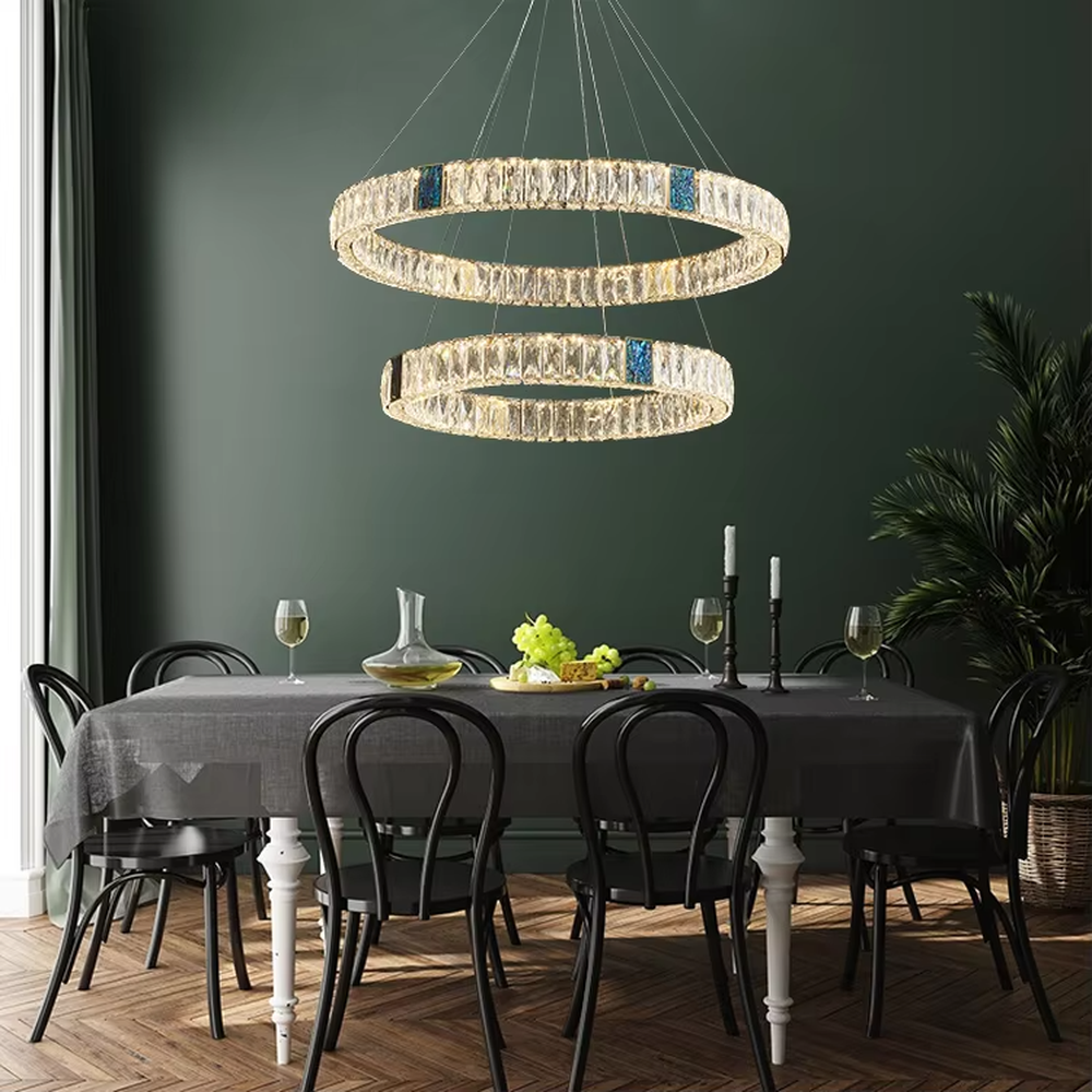 This light luxury and grand multi-layer conical crystal chandelier features a gold metal frame, with vertical-textured glass lampshades on the upper layer and multiple layers of transparent crystal tassels hanging below, creating a full conical shape. When lit, light refracts through the crystal to emit a brilliant and luxurious glow, combining elegant texture with an ambient atmosphere. Ideal for living rooms, dining rooms, villa high-ceiling spaces, and other areas, it adds an elegant and exquisite touch to European light luxury or modern luxury home environments.