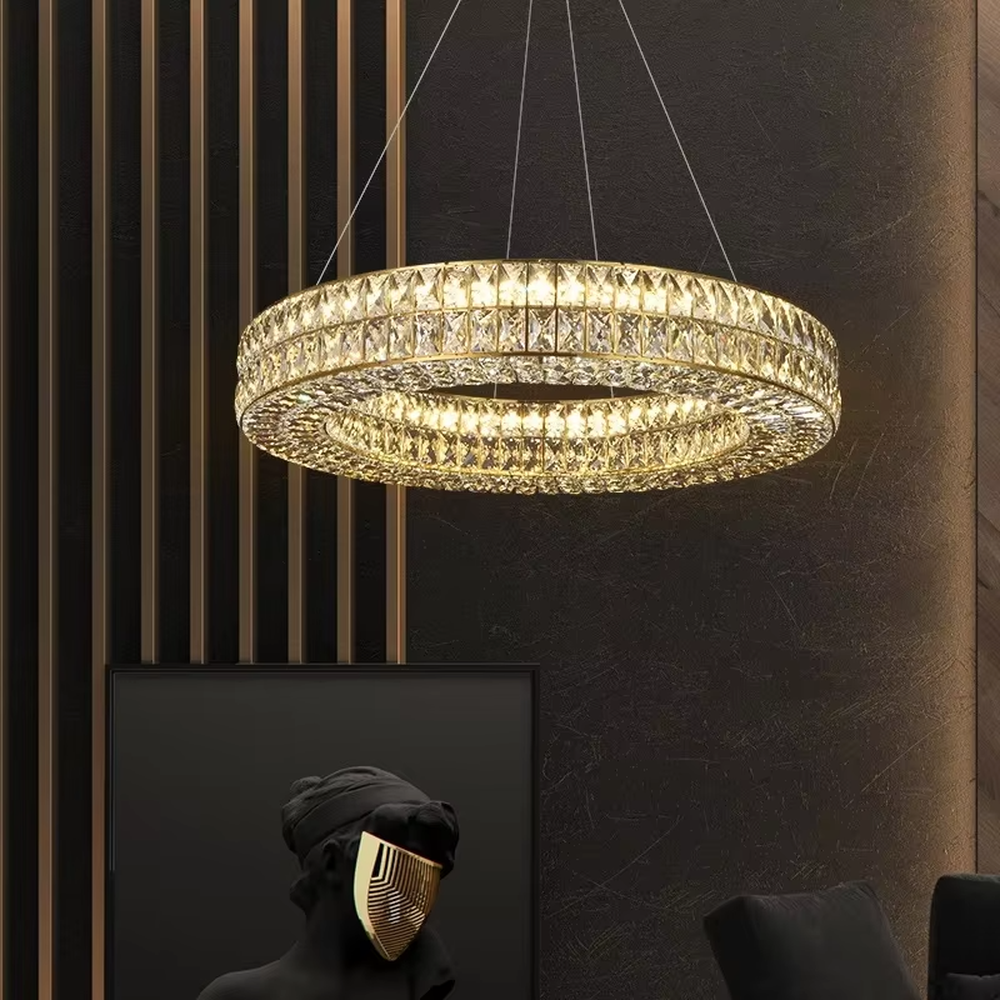 This modern light luxury linear crystal chandelier features a gold metal frame, inlaid with two layers of cut crystal blocks to form a square shape. When lit, light refracts through the crystals to emit a brilliant and luxurious glow, combining an exquisite texture with an ambient atmosphere. Ideal for dining rooms, bars, light luxury apartments, and other spaces, it adds an exquisite and sophisticated touch to modern minimalist or light luxury home environments.
