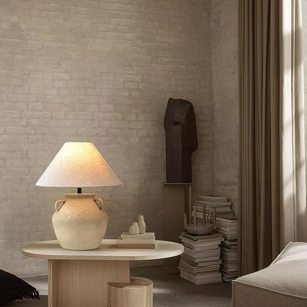 This is a retro clay pot - shaped table lamp with a beige textured clay pot base (with double handles) and a beige fabric slant lampshade, featuring a natural and rustic design with retro artistic sense. It is used for local desktop lighting and decoration, creating a warm retro atmosphere. It is suitable for wabi - sabi style home living rooms, retro - style homestays, art soft decoration display spaces and other places.