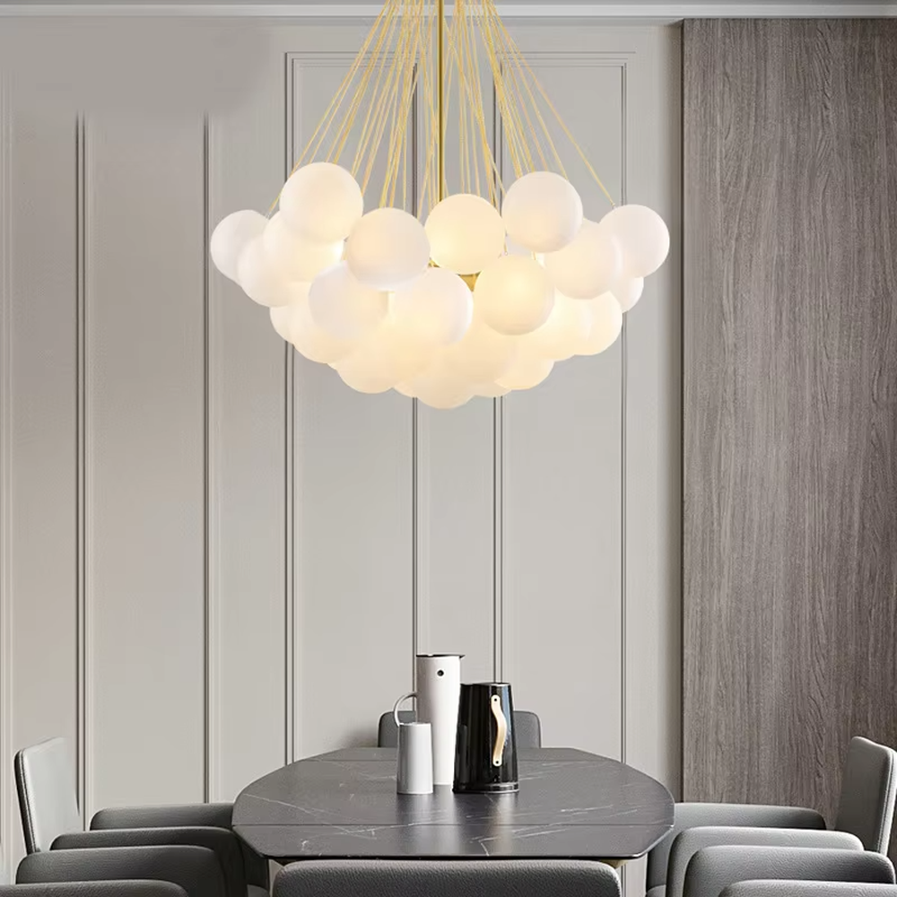 Modern healing cloud chandelier, featuring a radial suspension wire structure in black metal paired with fluffy milk-white frosted glass balls to form a cloud shape. It emits soft and gentle light, combining a dreamy feel and cozy ambiance, making it a decorative lighting fixture that enhances the warmth of the space.