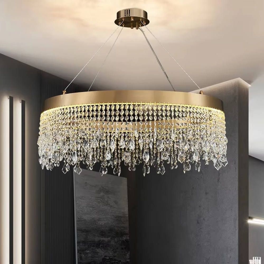 This modern light luxury circular tassel crystal chandelier features a champagne gold metal top frame, with dense crystal bead strings hanging down to form a tassel layered shape. When lit, light refracts through the crystals to emit a brilliant and soft glow, combining a luxurious texture with an ambient atmosphere. Ideal for living rooms, dining rooms, light luxury apartments, and other spaces, it adds an exquisite and sophisticated touch to modern minimalist or light luxury home environments.