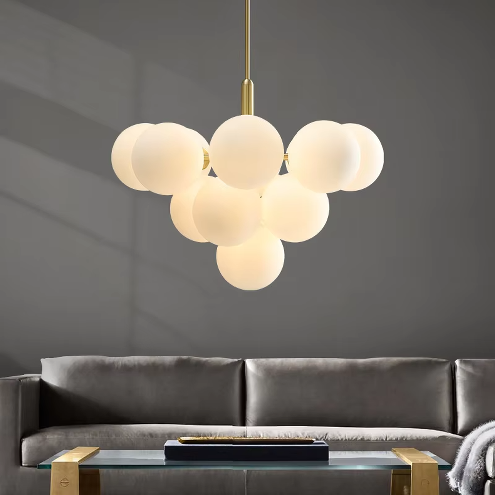 Modern healing cloud magic bean chandelier, featuring a brass metal frame paired with fluffy milk-white frosted glass balls to form a cloud shape. It emits soft and gentle light, combining a dreamy feel and cozy ambiance, making it a decorative lighting fixture that enhances the warmth of the space.