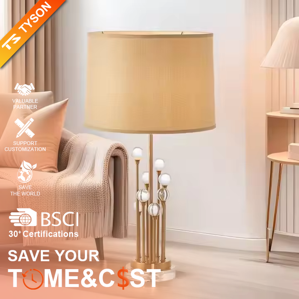This is a modern luxury-style table lamp with a golden metal stand, multiple spherical decorations, and a beige fabric lampshade that transmits light softly. It has an exquisite and layered design. It is used for local desktop lighting and decoration, combining practicality and aesthetics. It is suitable for modern home living room side tables, bedroom bedside tables, as well as high-end hotel guest rooms, luxury cafes and other places.