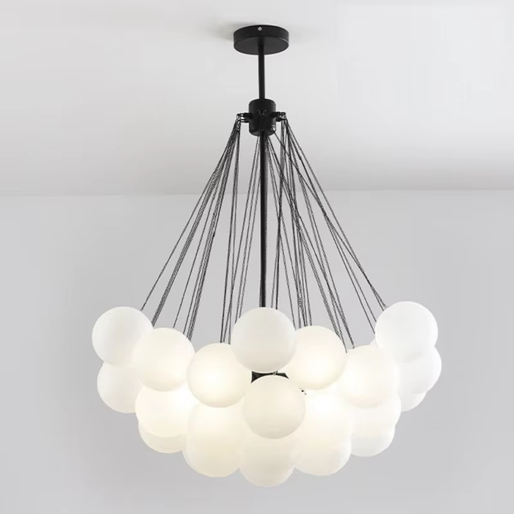 Modern healing cloud chandelier, featuring a radial suspension wire structure in black metal paired with fluffy milk-white frosted glass balls to form a cloud shape. It emits soft and gentle light, combining a dreamy feel and cozy ambiance, making it a decorative lighting fixture that enhances the warmth of the space.