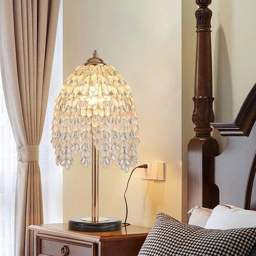 This is a luxury shell crystal table lamp with multi-layer shell-shaped crystal pendants, a golden bracket, and a black marble base, featuring a brilliant and luxurious design. It is used for local desktop lighting and decoration, creating a high-end luxurious atmosphere. It is suitable for luxury-style home bedroom bedside tables, high-end hotel guest rooms, European-style soft decoration spaces and other places.