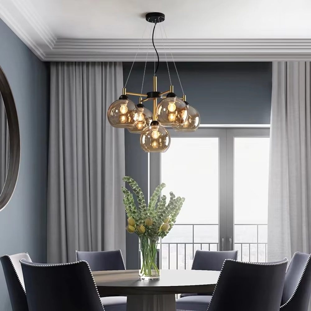 Modern light luxury black and gold branch chandelier, featuring a radial frame in black and gold metal paired with gradient smoky gray glass ball lampshades. Its sophisticated and layered design combines style and ambiance, making it a high-end decorative lighting fixture that elevates the space's aesthetic.