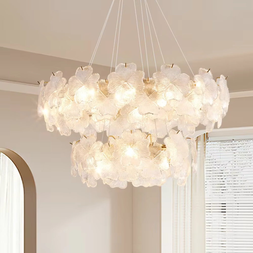This modern light luxury two-layer petal chandelier is suspended by white cords, composed of two layers of transparent glass petals arranged in a staggered layout with delicate textures. When lit, it emits a soft and gentle glow, combining a romantic ambiance with an ethereal feel. Ideal for living rooms, bedrooms, dining rooms, and other spaces, it adds a dreamy and exquisite touch to modern minimalist or French light luxury home environments.