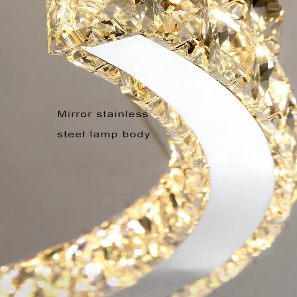 This modern light luxury double-ring interwoven crystal chandelier features a silver metal base, inlaid with transparent crystals to create a dynamic double-ring interwoven shape. When lit, light refracts through the crystal to emit a brilliant and dynamic glow, combining a futuristic feel with an ambient atmosphere. Ideal for living rooms, dining rooms, light luxury apartments, and other spaces, it adds an exquisite and sophisticated touch to modern minimalist or light luxury home environments.