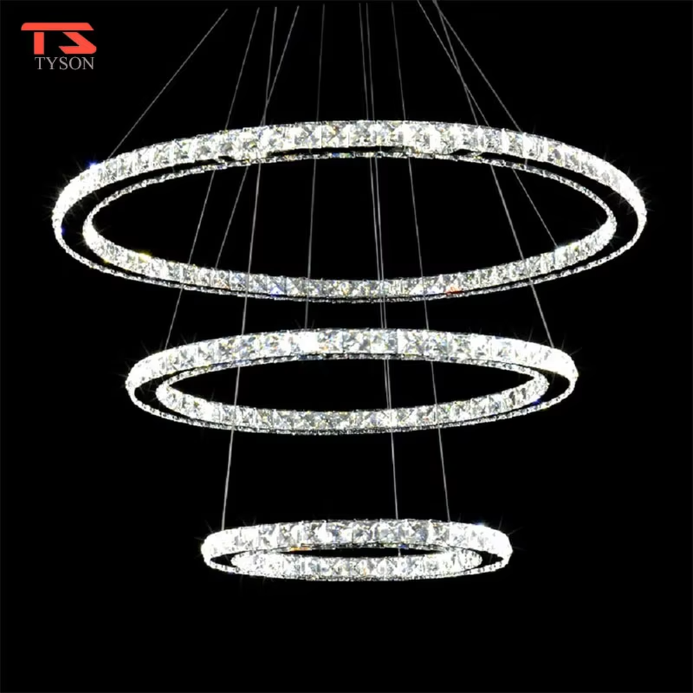 This modern light luxury interwoven ring crystal chandelier consists of transparent crystal rings of varying sizes interlaced and nested, suspended by silver cords. When lit, light refracts through the crystal to emit a brilliant and dynamic glow, combining a futuristic feel with an ambient atmosphere. Ideal for high-ceiling living rooms, villa foyers, light luxury apartments, and other spaces, it adds an exquisite and sophisticated touch to modern minimalist or light luxury environments.