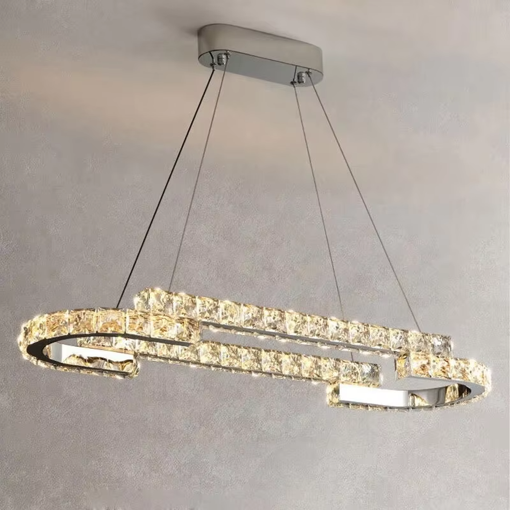 This modern light luxury double-ring interwoven crystal chandelier features a silver metal base, inlaid with transparent crystals to create a dynamic double-ring interwoven shape. When lit, light refracts through the crystal to emit a brilliant and dynamic glow, combining a futuristic feel with an ambient atmosphere. Ideal for living rooms, dining rooms, light luxury apartments, and other spaces, it adds an exquisite and sophisticated touch to modern minimalist or light luxury home environments.