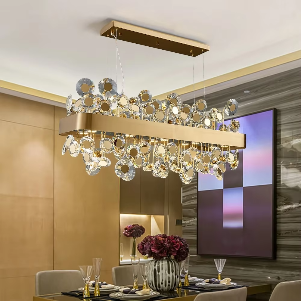 This modern light luxury rectangular crystal chandelier features a gold metal frame inlaid with multiple layers of circular-cut crystals and gold reflective discs. The staggered crystals create a brilliant and luxurious light effect when illuminated, combining decorative appeal with an ambient atmosphere. Ideal for dining rooms, bars, and above dining tables in light luxury apartments, it adds an elegant and exquisite touch to modern light luxury or European-style luxury spaces.
