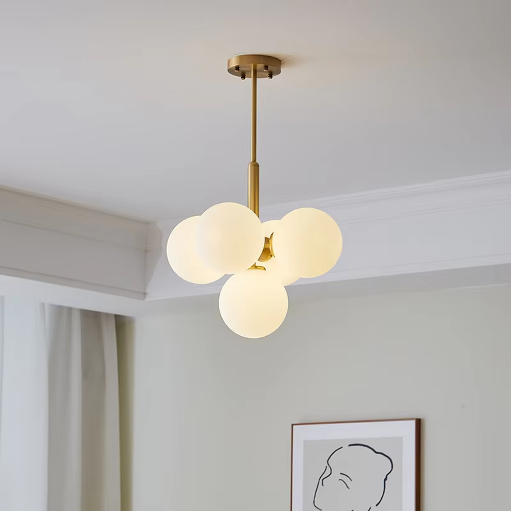 Modern light luxury gold magic bean chandelier, featuring a brass metal frame paired with clustered milk-white frosted glass balls. It emits soft and gentle light, combining warmth and style, making it a decorative lighting fixture that enhances the space's texture.