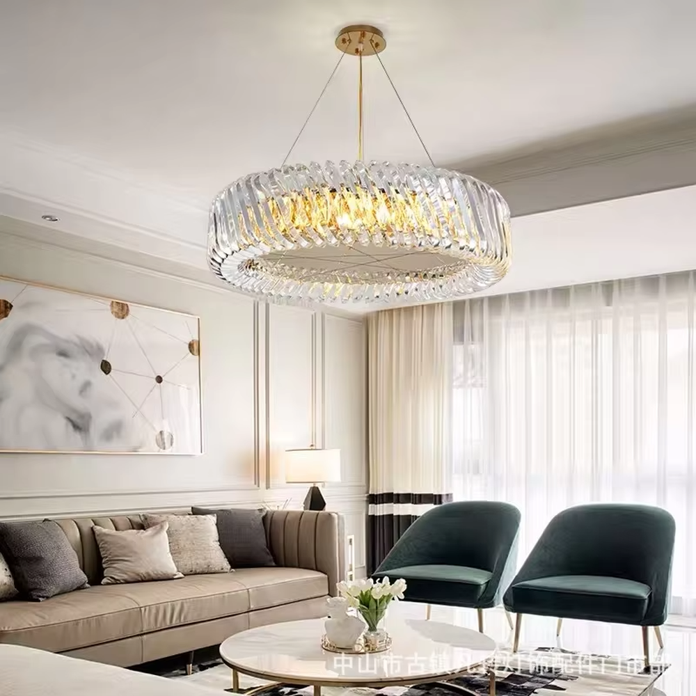 This modern light luxury linear crystal chandelier features a gold metal ceiling base, enclosed by wavy transparent crystal strips to form a full linear shape. When lit, light refracts through the crystal to emit a brilliant and soft glow, combining a transparent texture with an ambient atmosphere. Ideal for dining rooms, bars, light luxury apartments, and other spaces, it adds an exquisite and sophisticated touch to modern minimalist or light luxury home environments.