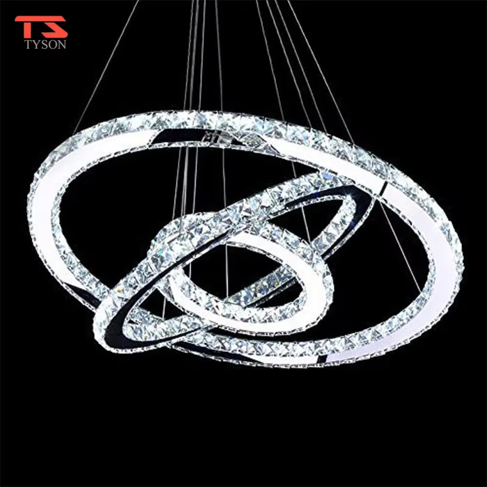 This modern light luxury interwoven ring crystal chandelier consists of transparent crystal rings of varying sizes interlaced and nested, suspended by silver cords. When lit, light refracts through the crystal to emit a brilliant and dynamic glow, combining a futuristic feel with an ambient atmosphere. Ideal for high-ceiling living rooms, villa foyers, light luxury apartments, and other spaces, it adds an exquisite and sophisticated touch to modern minimalist or light luxury environments.