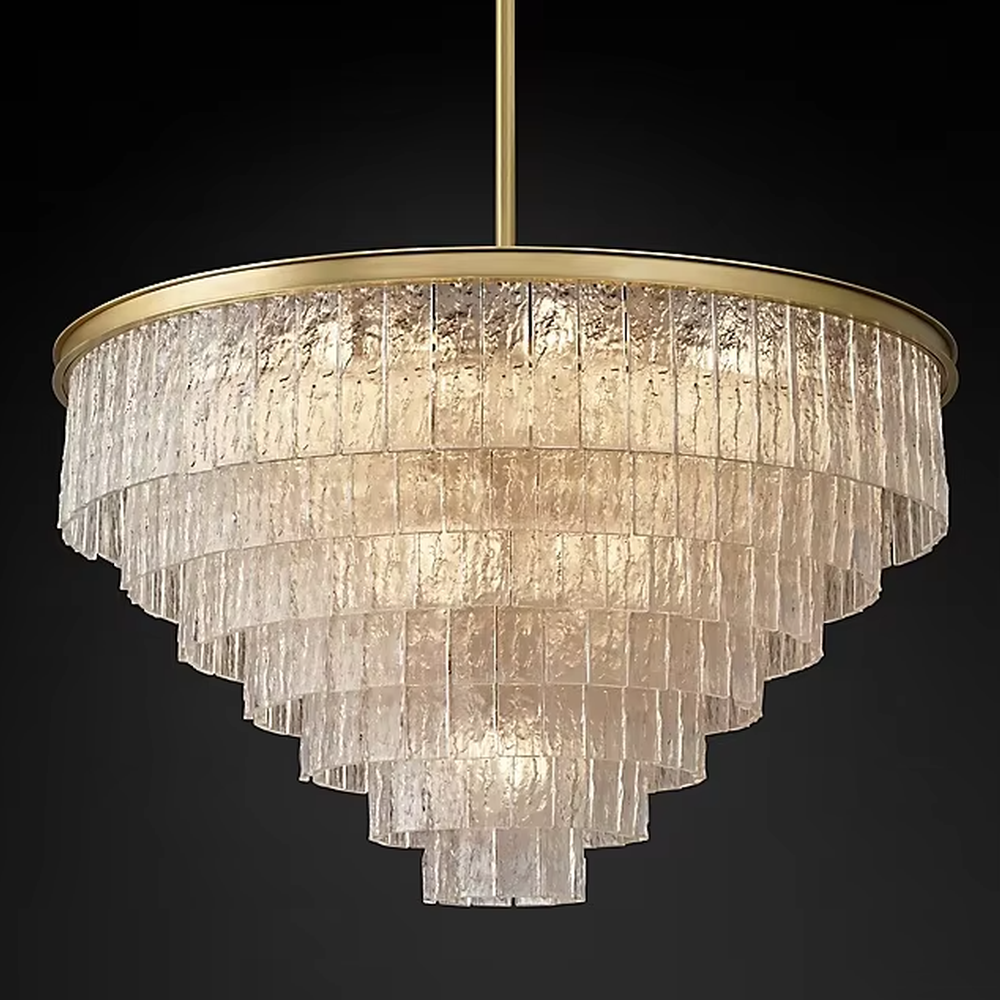 This modern light luxury layered conical chandelier features a gold metal top frame, with multiple layers of textured glass strips hanging down to form a conical layered shape. When lit, light refracts through the glass to emit a brilliant and soft glow, combining a luxurious texture with an ambient atmosphere. Ideal for high-ceiling living rooms, villas, light luxury apartments, and other spaces, it adds an exquisite and sophisticated touch to modern minimalist or light luxury home environments.
