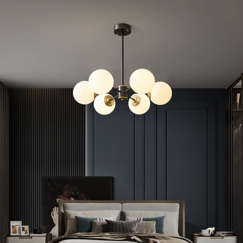 Modern light luxury magic bean chandelier, featuring a radial frame in black and gold metal paired with milk-white frosted glass ball lampshades. Its minimalist, rounded, and layered design combines warmth and style, making it a decorative lighting fixture that enhances the space's texture.
