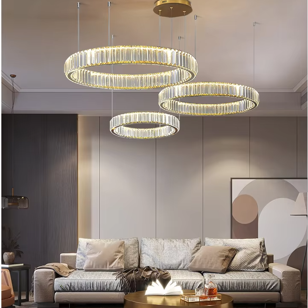 This modern light luxury multi-layer circular crystal chandelier features gold metal frames, inlaid with transparent long crystals to create three groups of staggered circular shapes. When lit, light refracts through the crystals to emit a brilliant and soft glow, combining a layered texture with an ambient atmosphere. Ideal for high-ceiling living rooms, duplex apartments, light luxury apartments, and other spaces, it adds an exquisite and sophisticated touch to modern minimalist or light luxury home environments.