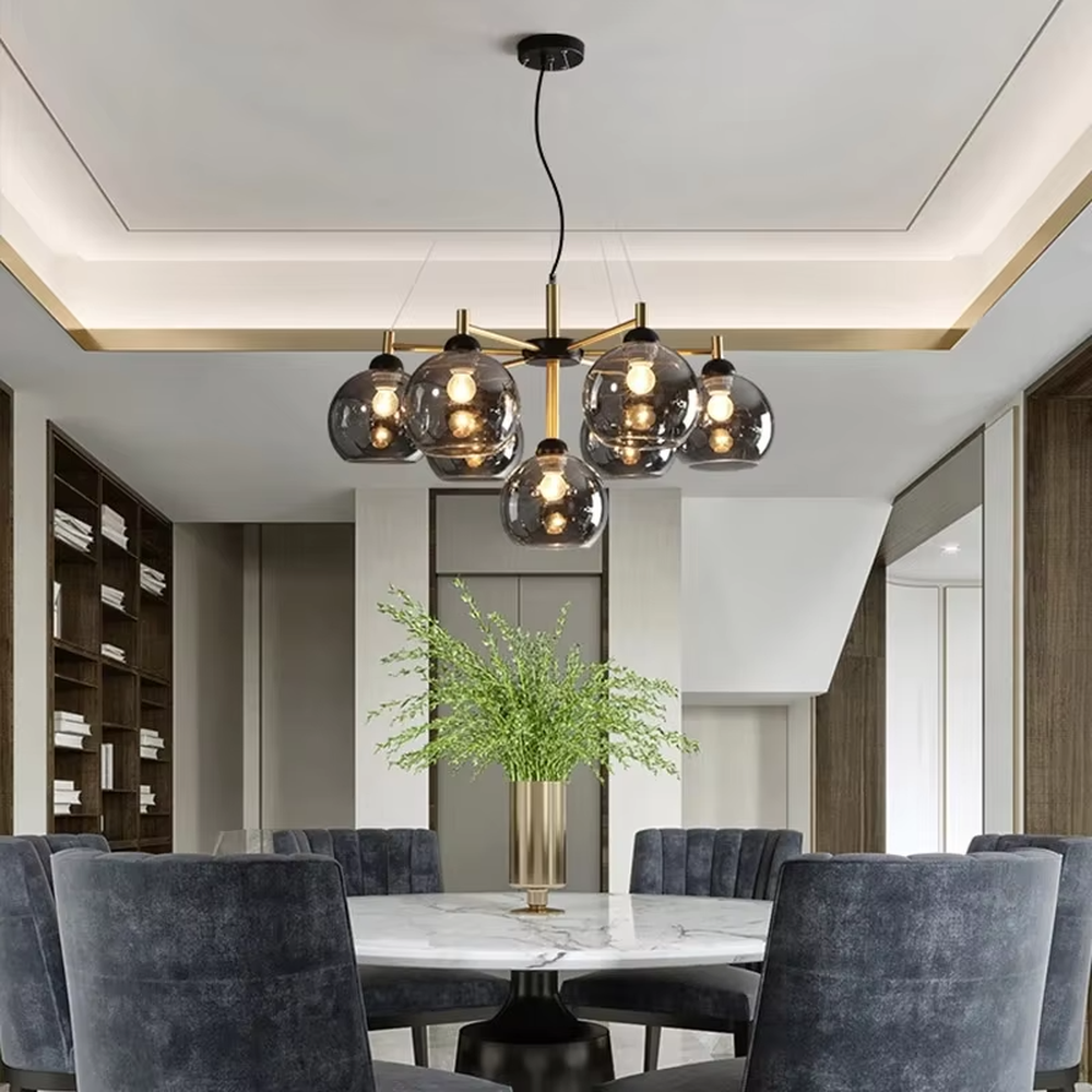 Modern light luxury black and gold branch chandelier, featuring a radial frame in black and gold metal paired with gradient smoky gray glass ball lampshades. Its sophisticated and layered design combines style and ambiance, making it a high-end decorative lighting fixture that elevates the space's aesthetic.