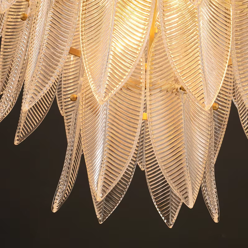 This modern light luxury feather glass chandelier features a gold metal frame, with layered textured feather-shaped glass slices forming a fan shape. When lit, light refracts through the glass to emit a soft and brilliant glow, combining an ethereal texture with an ambient atmosphere. Ideal for living rooms, dining rooms, light luxury apartments, and other spaces, it adds a dreamy and exquisite touch to modern minimalist or French light luxury home environments.