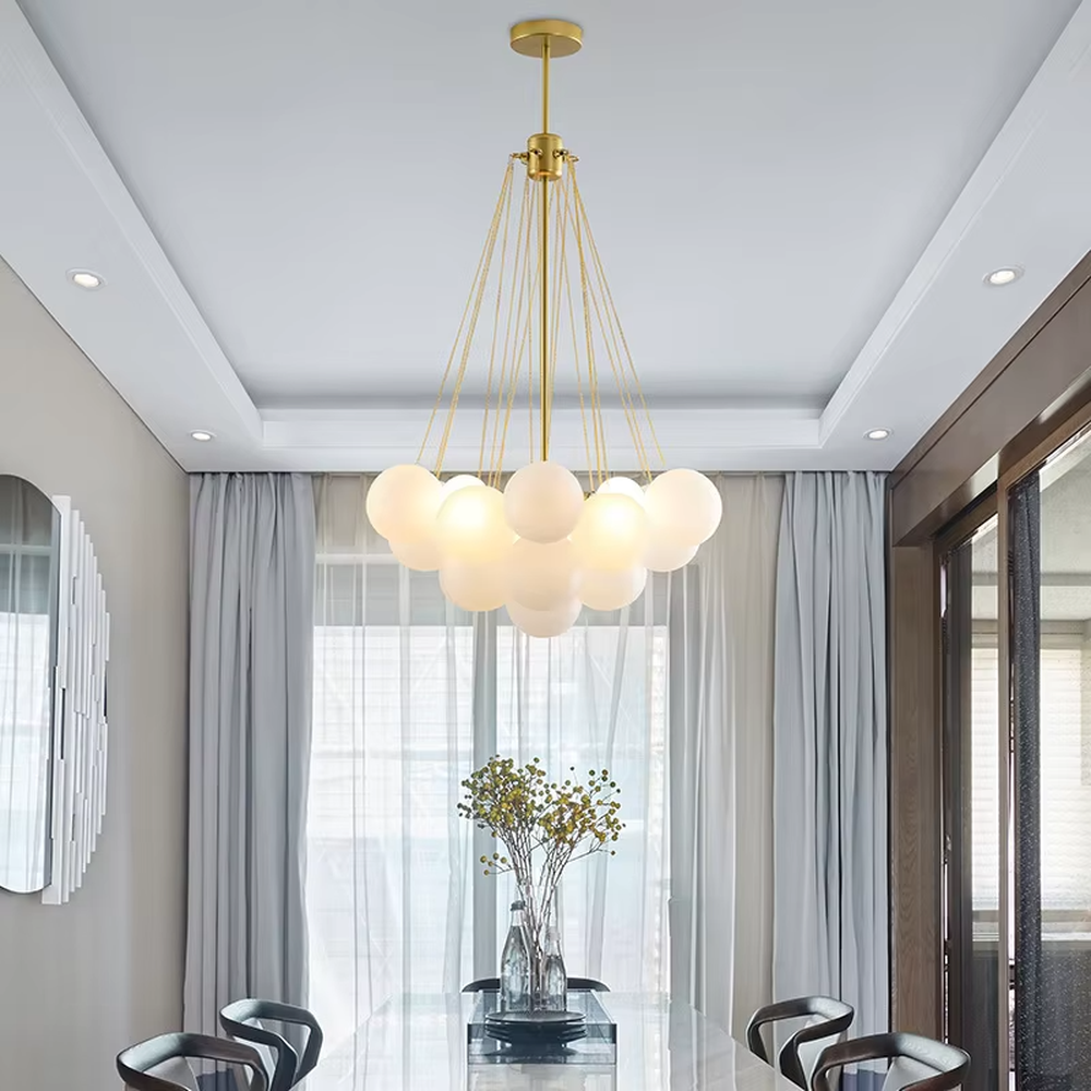 This modern light luxury milk-white cluster chandelier features a gold metal frame, paired with multiple milky white frosted glass ball lampshades arranged in a cloud-like staggered layout. When lit, it emits a soft and gentle glow, combining romantic ambiance with design appeal. Ideal for living rooms, dining rooms, bedrooms, and other spaces, it adds a warm and exquisite touch to modern light luxury, Nordic, or minimalist home environments.