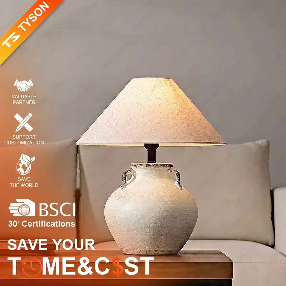 This is a retro clay pot - shaped table lamp with a beige textured clay pot base (with double handles) and a beige fabric slant lampshade, featuring a natural and rustic design with retro artistic sense. It is used for local desktop lighting and decoration, creating a warm retro atmosphere. It is suitable for wabi - sabi style home living rooms, retro - style homestays, art soft decoration display spaces and other places.