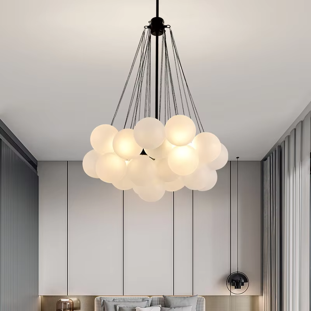 This modern light luxury milk-white cluster chandelier features a gold metal frame, paired with multiple milky white frosted glass ball lampshades arranged in a cloud-like staggered layout. When lit, it emits a soft and gentle glow, combining romantic ambiance with design appeal. Ideal for living rooms, dining rooms, bedrooms, and other spaces, it adds a warm and exquisite touch to modern light luxury, Nordic, or minimalist home environments.