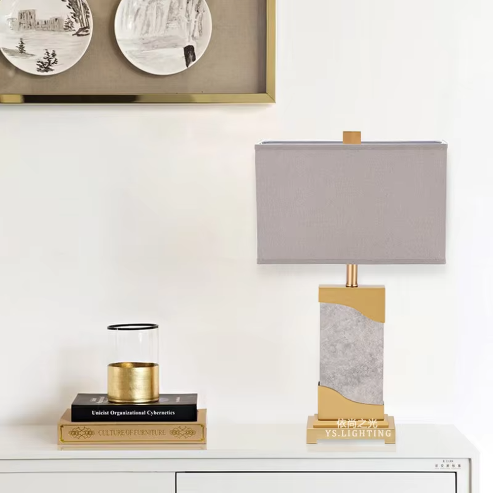 This is a luxury black-gold marble table lamp, with a golden metal frame, black-veined marble (with curved design), and a white fabric square lampshade, featuring a minimalist luxury design with high-quality texture. It is used for local desktop lighting and decoration, creating a high-end luxury atmosphere. It is suitable for luxury-style home bedroom bedside tables, high-end hotel guest rooms, modern soft decoration display spaces and other places.