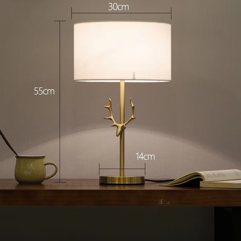 Light luxury golden antler-shaped table lamp, white cylindrical fabric lampshade + golden base, soft and warm lighting, creating a natural elegant atmosphere.