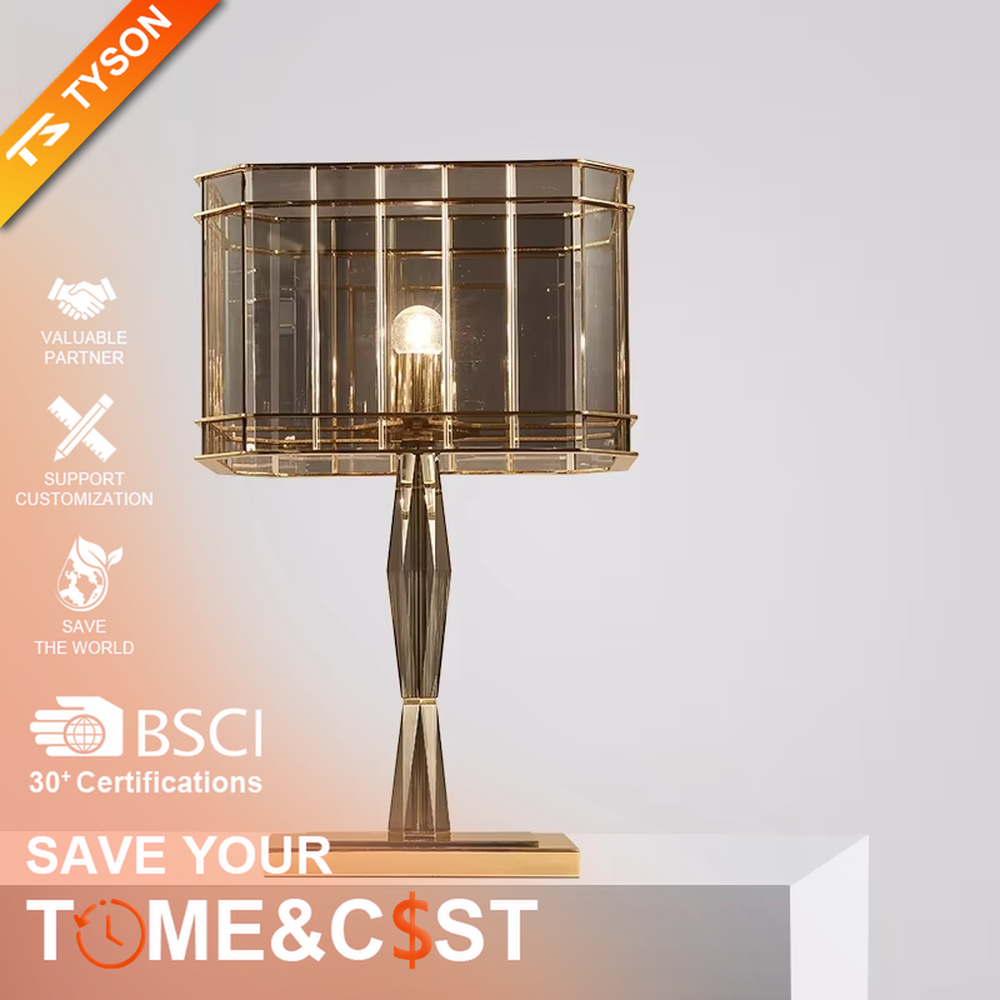 This is a light luxury and luxurious smoky gray glass metal table lamp, with a smoky gray glass lampshade paired with a golden metal frame, a golden base, and a geometrically cut lamp post. It features an exquisite and grand design, with soft and textured lighting through the glass. It is used for local desktop lighting and decoration, creating a light luxury and luxurious atmosphere. Suitable for light luxury-style bedroom bedside tables, luxury living room side tables, high-end hotel guest rooms and other places.