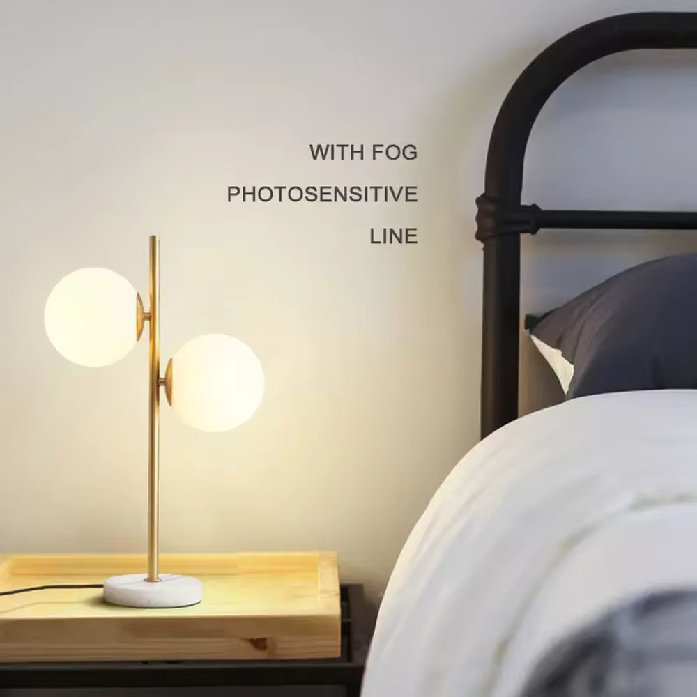 This is a modern light luxury double-ball table lamp, with a golden lamp pole paired with frosted white ball lampshades and a white marble base. The style is simple and exquisite, with soft and warm lighting.